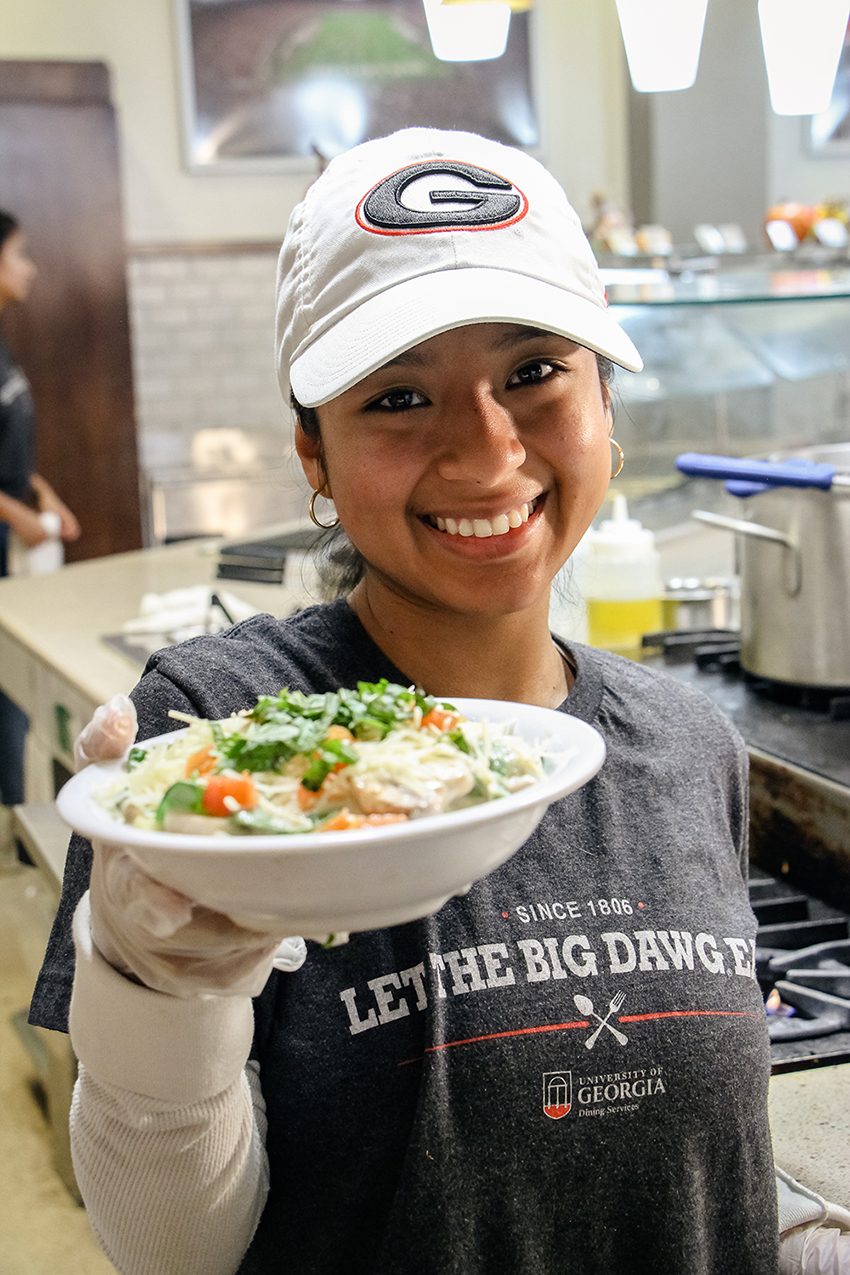 Dining team member hands out a box of food.